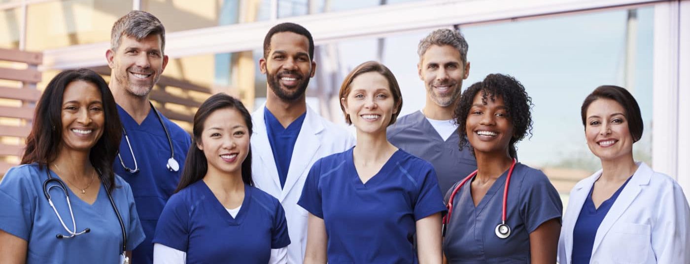 Smiling medical team standing together outside a hospital